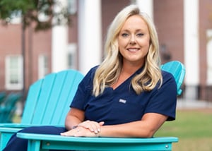 Caroline Jenkins '19, '26DNP sitting outside on campus